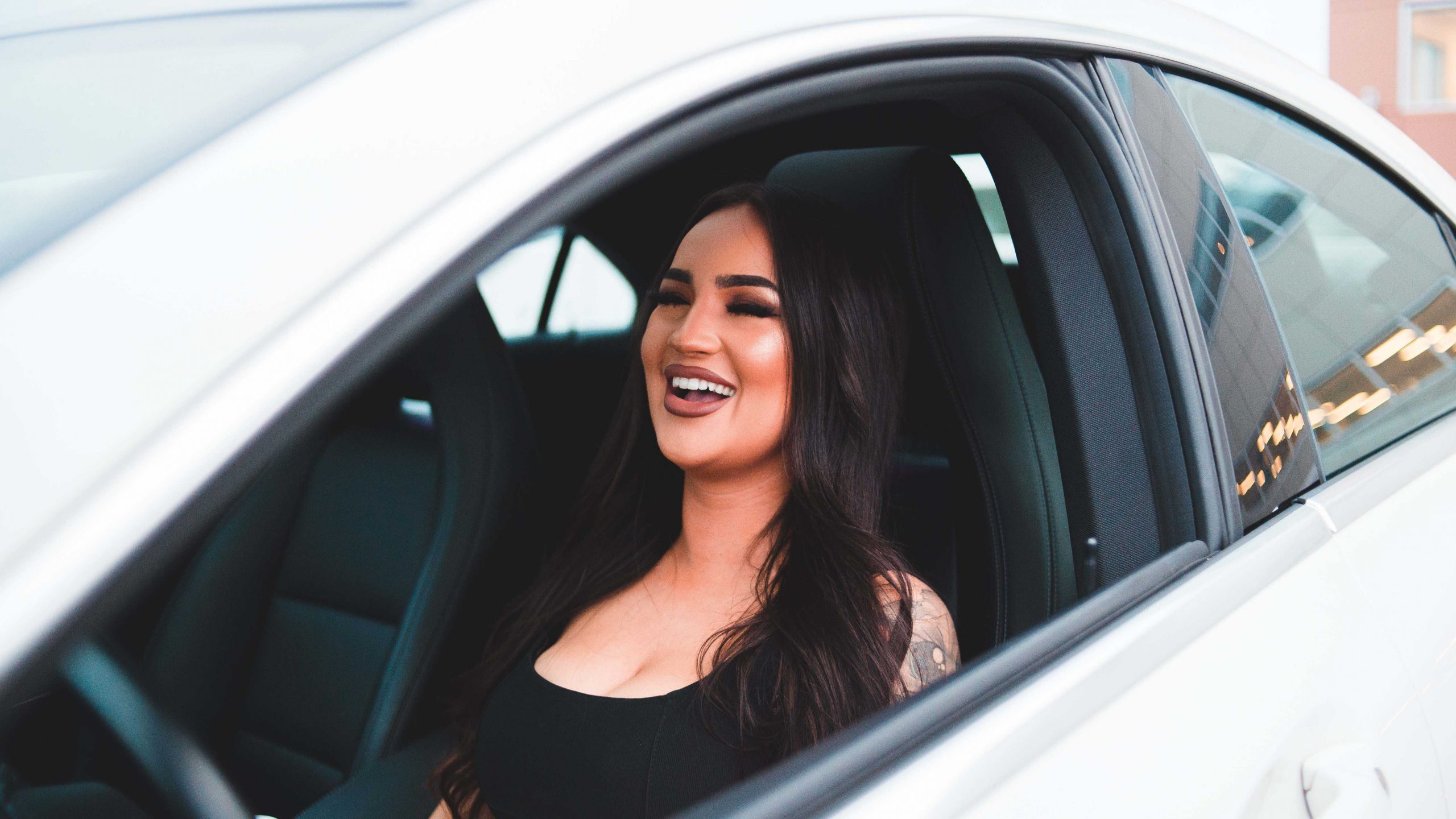 Online auto theorie, glimlachende vrouw in de auto